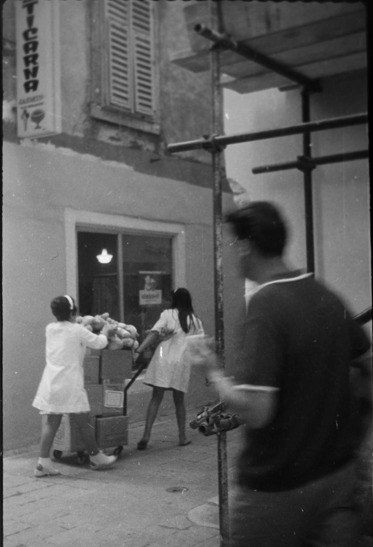Similar girls bringing meat to a nearby shop. Note the length of the smock.